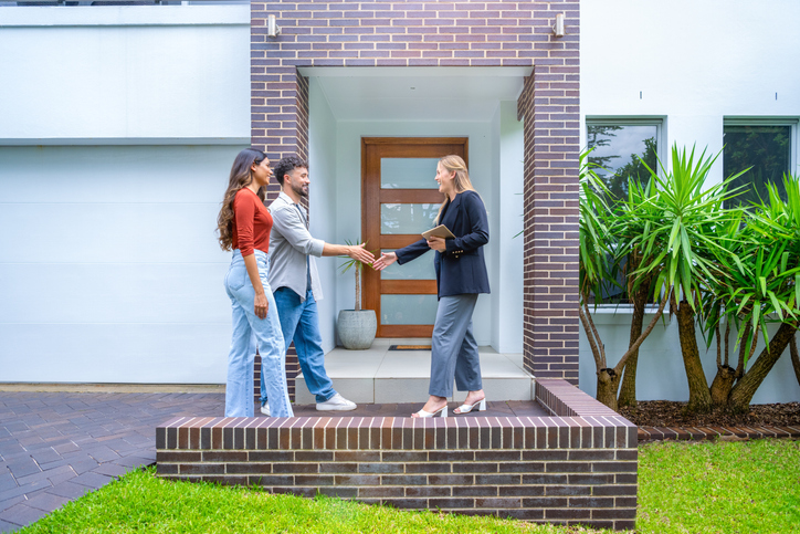 A real estate agent is showing a rental property to the couple.