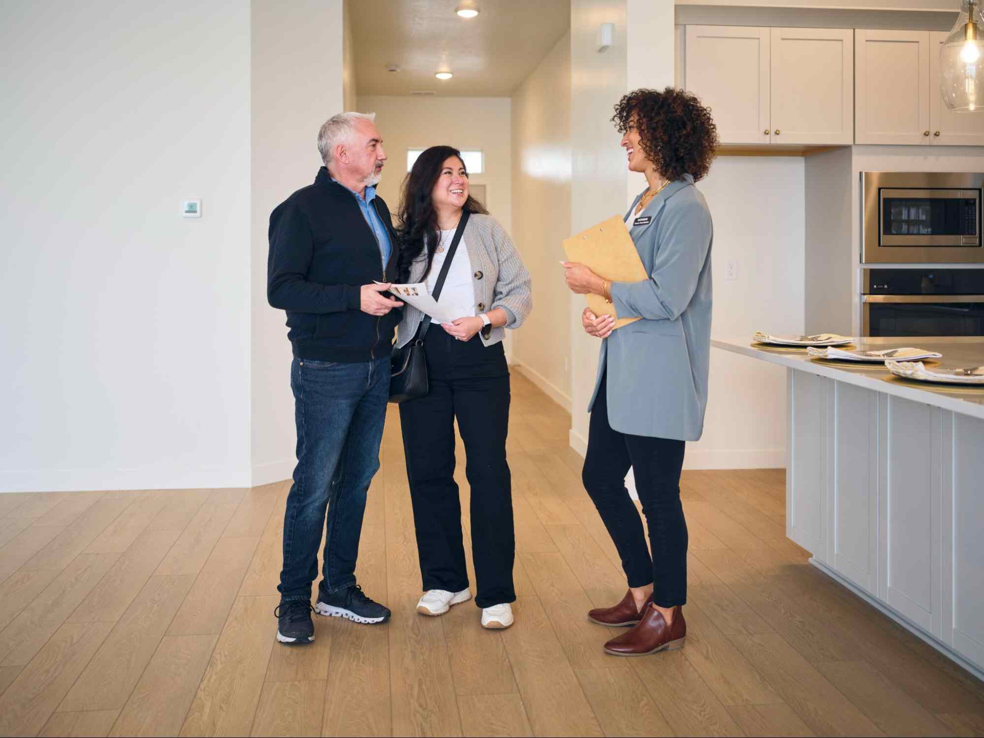 Property manager meeting with homeowners in a modern home highlighting the benefits of hiring a property manager for property oversight and maintenance.