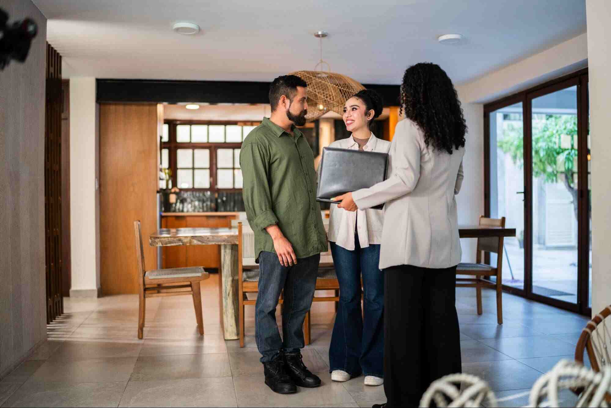 Property manager discussing strategy with homeowners inside a residence illustrating what is a property asset management plan.