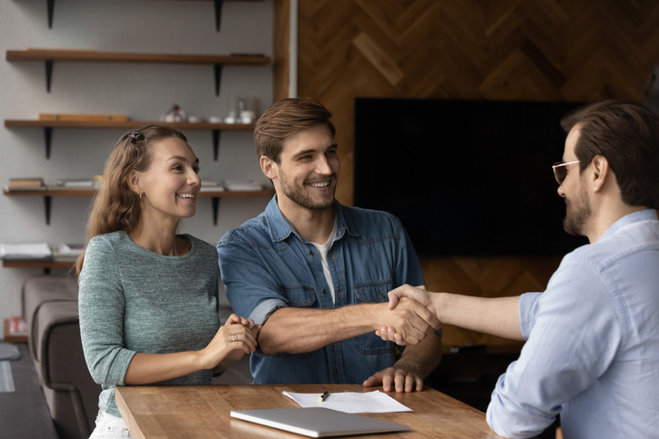Tenant screening process shown by a landlord meeting and approving prospective tenants during a rental application discussion.