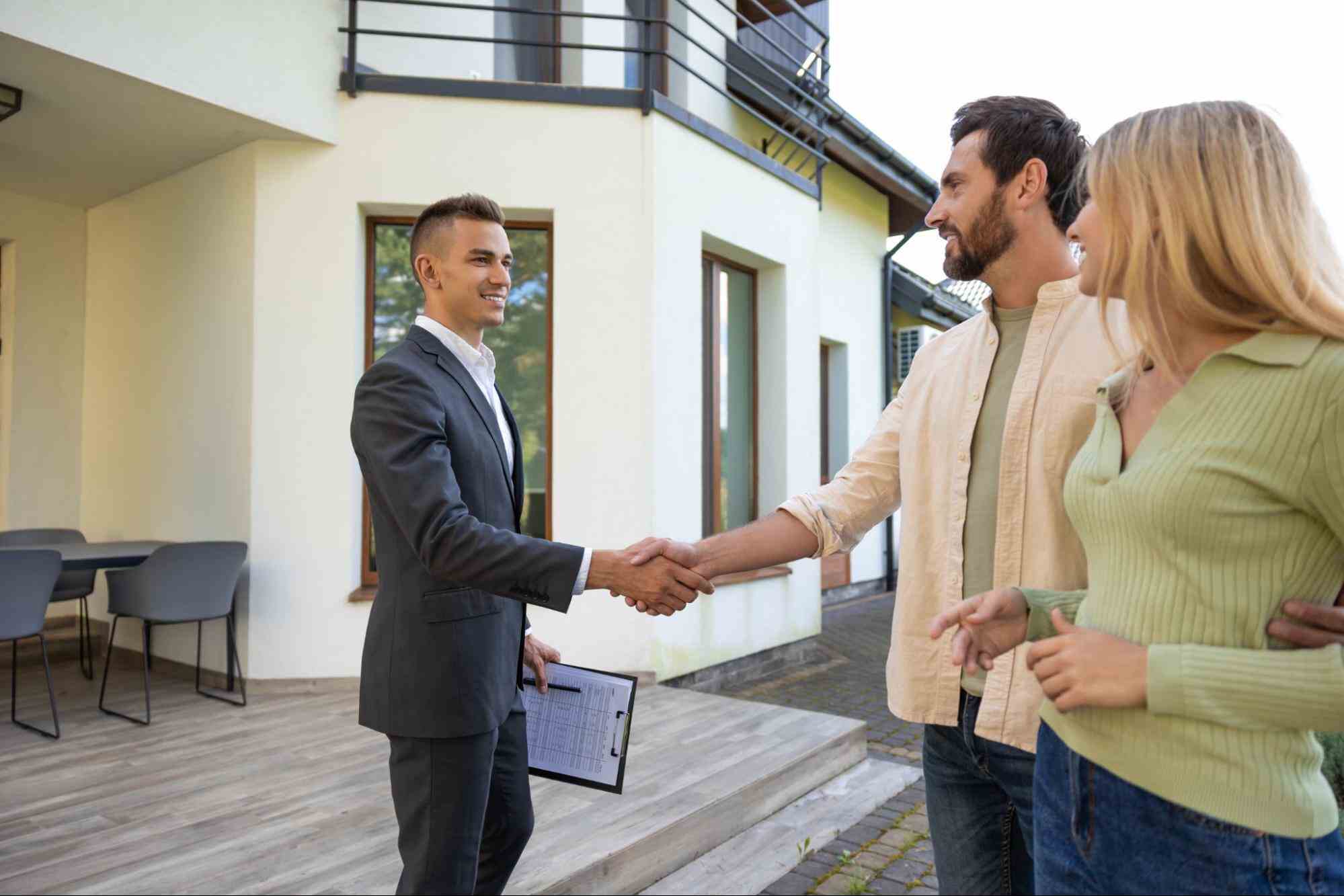 Property Manager meeting with prospective tenants outside a residential property, illustrating how a recession affects the rental market and housing demand.