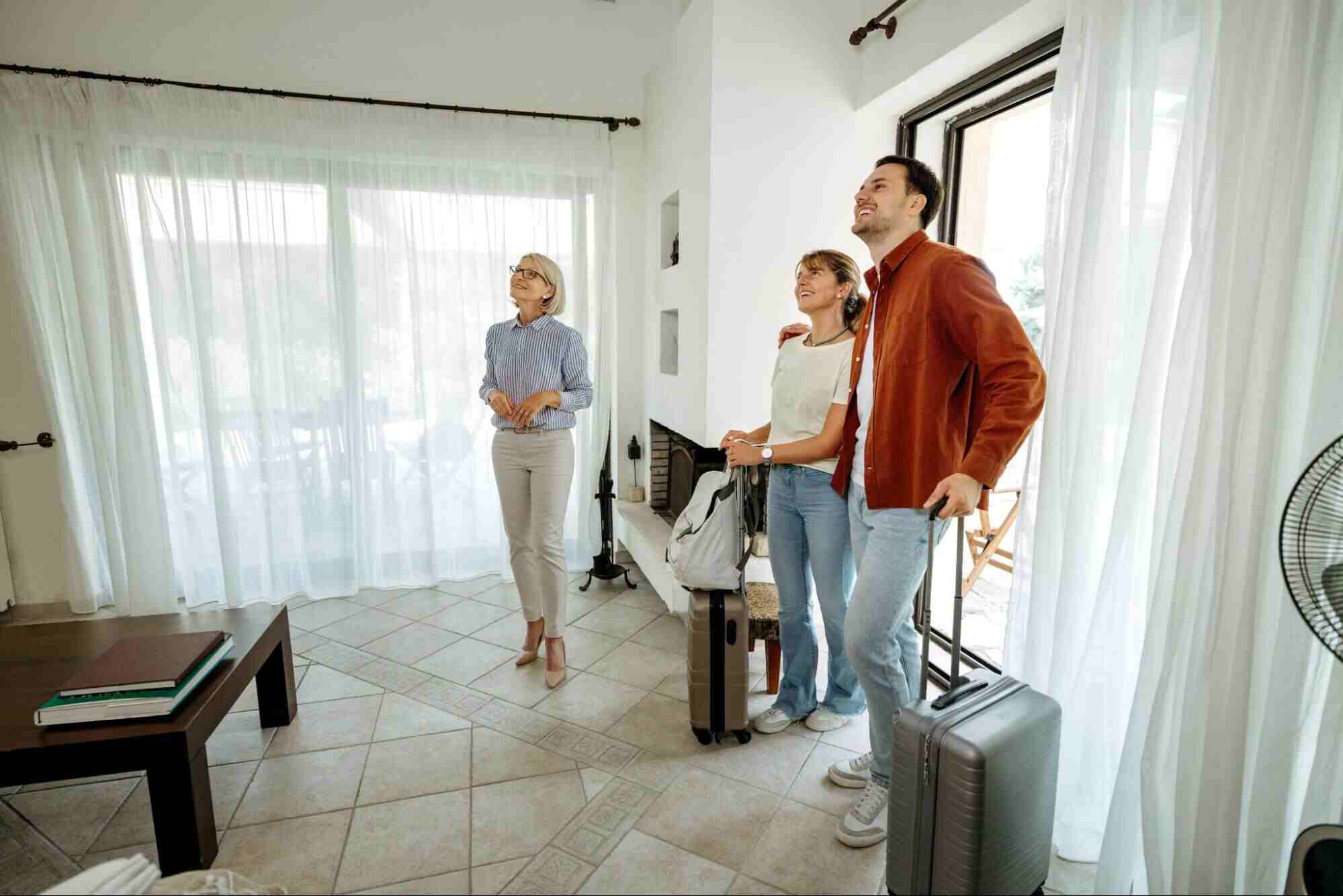 Property manager showing a rental home to prospective tenants, illustrating what is the cost of property management.